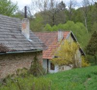 Bukoveci családi ház régi téglafallal, zöld környezettel és fákkal körülvéve.