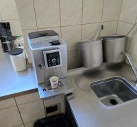 Konyhasarok kávéfőzővel, rozsdamentes acél mosogatóval és szükséges eszközökkel a vendéglátóipari helyiségekben.
