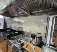 Konyhai berendezés vendéglátóipari helyiségekben grillel és fritőzzel az ételek elkészítéséhez.