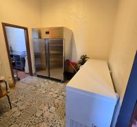 Hűtőhelyiség csempével a vendéglátóipari területeken, amely tartalmaz egy fémszekrényt és egy fagyasztót.