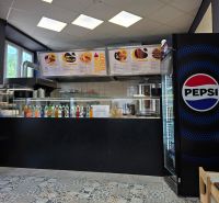 Vendéglátóhelyiség italválasztékkal, Pepsi hűtővel és mintás csempével.
