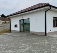 Családi ház a Fő utcán, Vágfarkasdon fehér homlokzattal és kövezett udvarral.