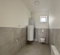 Családi ház fürdőszobája WC-vel és vízmelegítővel.