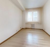 Világos szoba ablakkal és fa dekorációjú padlóval egy kétszobás lakásban.