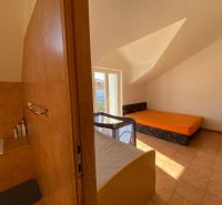 Nyaraló apartman belső tere kanapéval, ággyal és gyerekággyal.