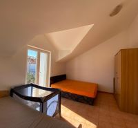 Nyaraló apartman hálószobája ágyakkal, szekrénnyel és gyerekággyal.