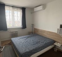 Hálószoba egy kétszobás lakásban, fa dekorációjú szőnyegekkel a padlón.