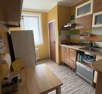 A kétszobás lakás konyhája, berendezett konyhabútor és fa dekorációjú padló.