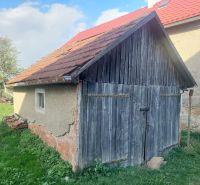 Régi fa garázs egy lakótelek Budinán, zölddel és fákkal körülvéve.