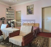 Nappali virágokkal és antik bútorokkal egy családi házban.