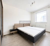 Hálószoba ággyal, szekrénnyel és fa dekorációjú padlóval egy kétszobás lakásban.