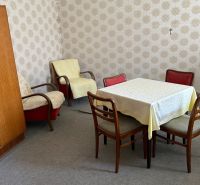 Szoba családi házban retro bútorokkal, tapétákkal és szőnyegpadlóval.