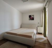 Világos hálószoba családi házban, ággyal és fa dekorációjú padlóval.
