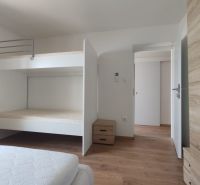 Hálószoba emeletes ággyal, fa mintázatú padlóval és tárolóhellyel egy családi házban.