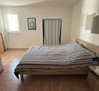 Hálószoba családi házban ággyal, kerámia padlóval és minimalista dekorációval.