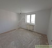 Üres szoba egy családi házban, fehér falak, műanyag burkolat a padlón.