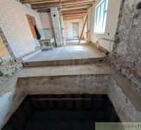 Családi ház belső tere felújítás alatt, feltárt falakkal és lépcsőházzal.