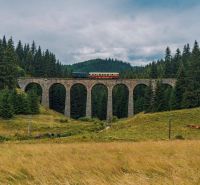 Telgárton a vonat egy kőviadukton halad, erdőkkel és rétekkel körülvéve.