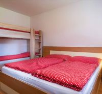 A rekreációs apartman kényelmes hálószobát kínál emeletes ággyal és fa dekorációjú padlóval.