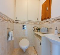 Fürdőszoba a háromszobás lakásban WC-vel, mosdóval és szekrénnyel.