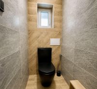 WC egy családi házban fekete WC-vel és fa dekorációjú padlóval.