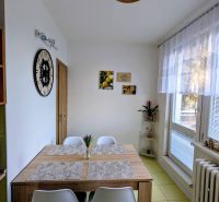 Ebédlő egy kétszobás lakásban étkezőasztallal és dekorációkkal.
