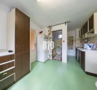 Konyha családi házban zöld padlóval és fa dekorációval a szekrényeken.