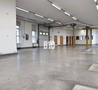 Világos gyártóterület betonpadlóval és magas mennyezettel.