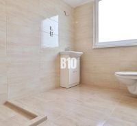 Fürdőszoba mosdóval és WC-vel egy családi házban csempézett burkolattal.
