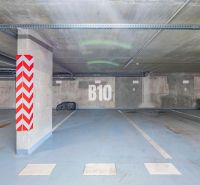 Földalatti parkolóhely Nyitrán kijelölt parkolóhellyel és beton oszlopokkal.