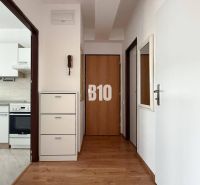 Folyosó fa dekorációs padlóval a Nyaraló apartmanban, a háttérben a konyha.