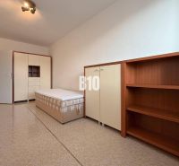 Világos szoba a Rekreációs apartmanban ággyal, szekrénnyel és polcrendszerrel.