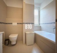 Fürdőszoba a nyaraló apartmanban káddal, WC-vel és modern burkolatokkal.