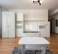 A fehér bútorokkal és fa dekorációjú padlóval rendelkező nyaraló apartman belső tere.