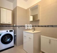 Fürdőszoba mosógéppel, mosdóval és szekrényekkel a Rekreačnom apartmanban.