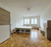 3 szobás lakás szobája ággyal és bútorral, fa mintázatú padlóval.