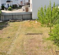 Kert a családi ház mögött, gyep és fák a Nabr. J. M. Hurbana utcában, Michalovce városában.