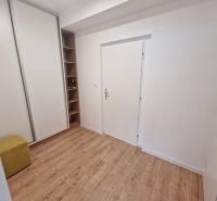 Előszoba egy kétszobás lakásban, fa mintázatú padlóval és beépített szekrénnyel.