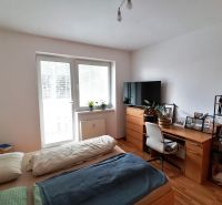 Hálószoba zóna egy egyszobás lakásban fa dekor padlóval és íróasztallal.