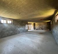 A befejezetlen házikó belső tere betonfalakkal és padlóval.