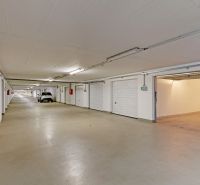Tágas garázsok Pozsony-Petržalkán több parkolóhellyel és világítással.