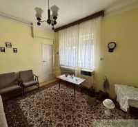 Nappali egy családi házban szőnyeggel és függönyökkel. A retro bútorok kiegészítik a hangulatos légkört.