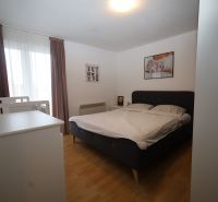 Hálószoba ággyal és gyermekággyal a nyaraló apartmanban, fa dekor padlóval.