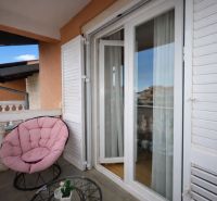 Rekreációs apartman erkélye kényelmes székkel és kilátással Vodicére.