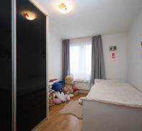 Gyerekszoba a Nyaraló apartmanban játékokkal, ággyal és fa dekorációjú padlóval.