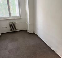 Irodai szoba szőnyeggel, radiátorral és redőnyös ablakkal.