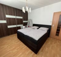 Hálószoba egy kétszobás lakásban nagy szekrénnyel és fa dekorációjú padlóval.