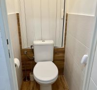 WC a kétszobás lakásban fa dekor padlóval.
