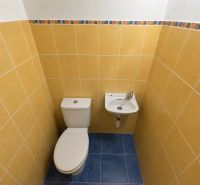 WC mosdóval a fürdőszobában, színes csempékkel egy kétszobás lakásban.
