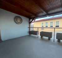 Fedett terasz órákkal és virágtartókkal a gyártóhelyiségekben.